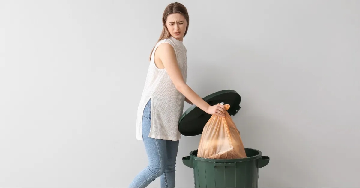 Woman putting garbage in trash bin