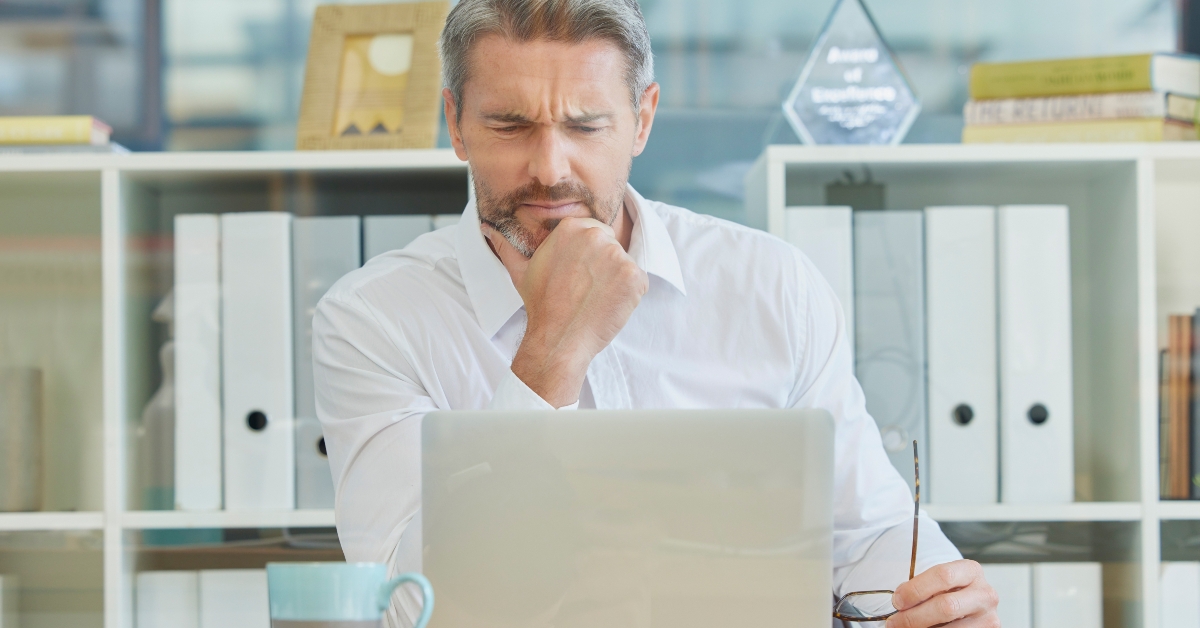 businessman thinking infront of laptop
