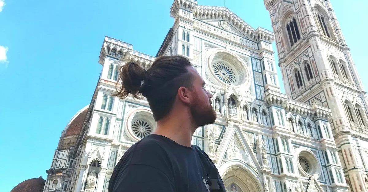 A man with ponytail hair looking a far