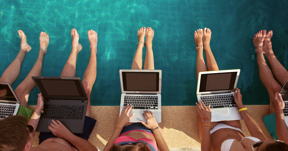 freelancers using laptop computer sitting near swimming pool