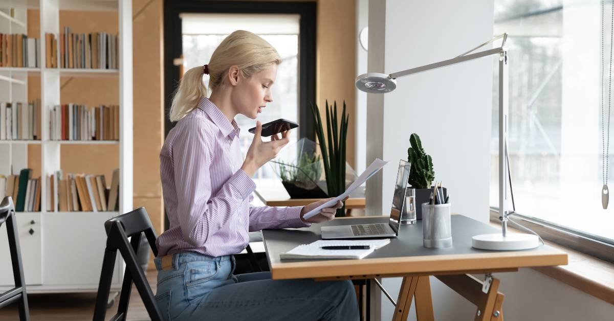 female entrepreneur giving command to virtual assistant on cellphone