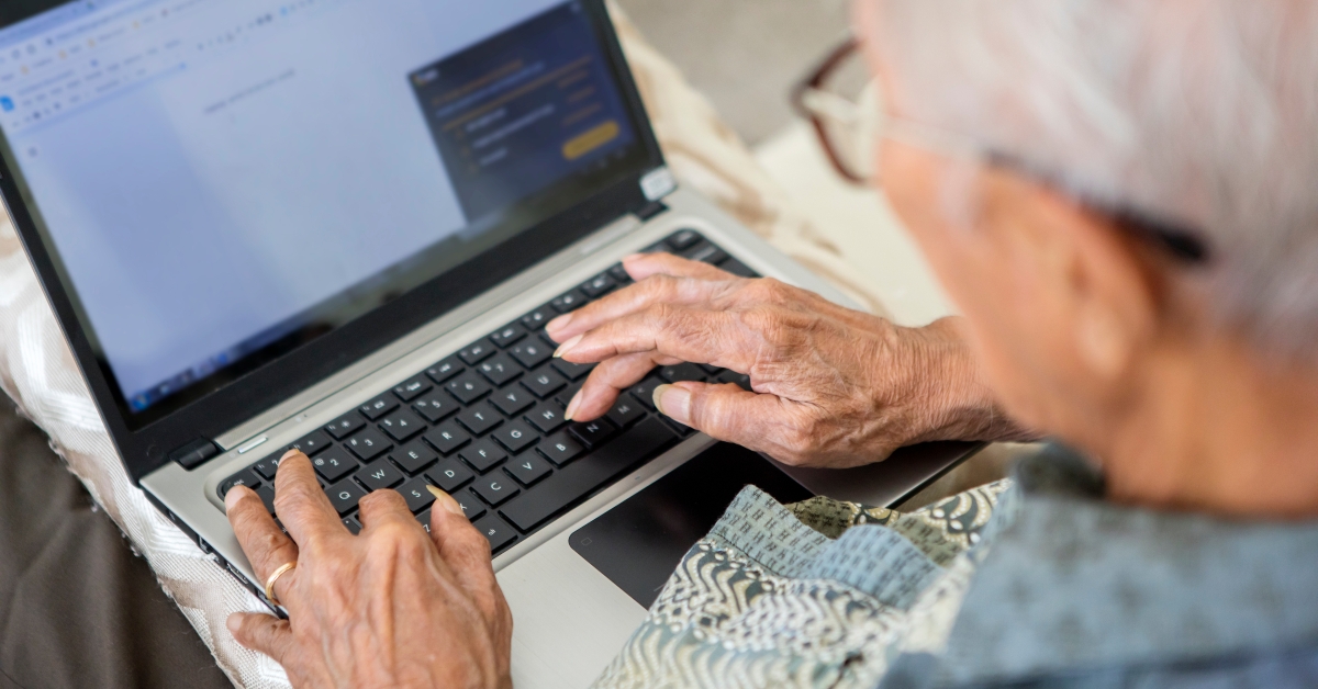 elderly man typing on the laptop 