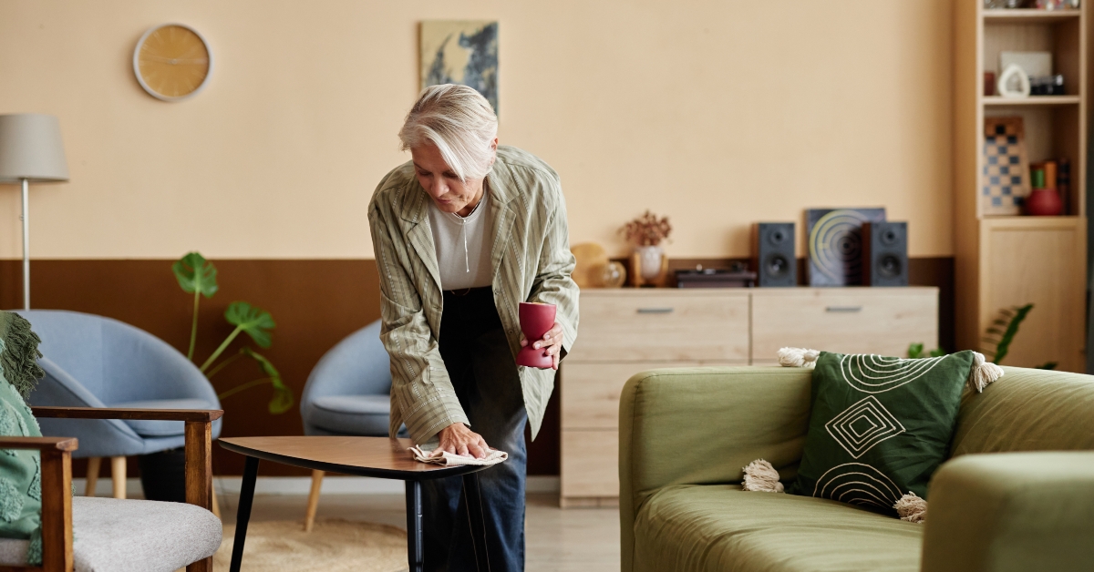 woman cleaning home and dusting coffee table