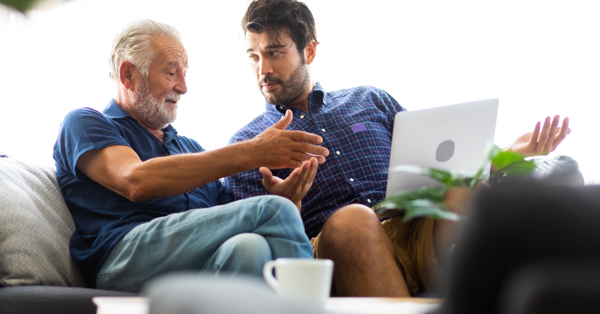 father and son talking while sitting on sofa