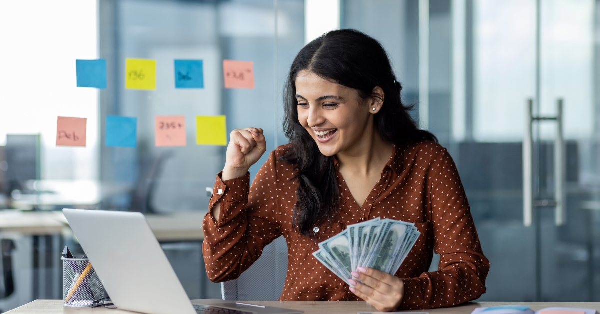happy young businesswoman holding money