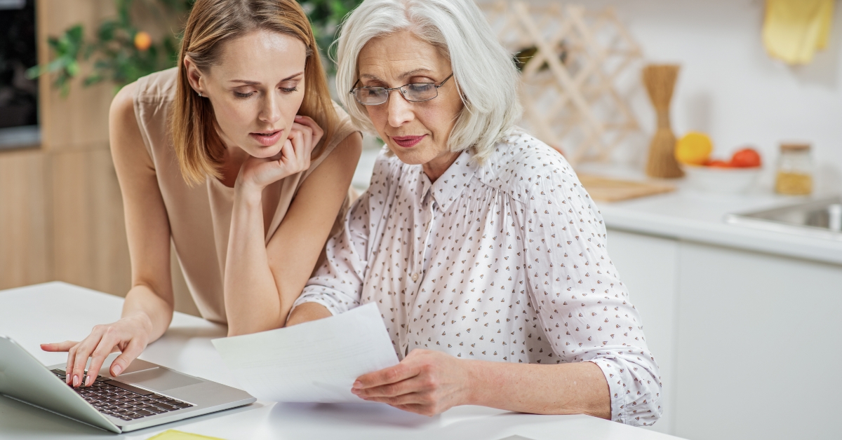 woman explaining some documentation to senior parent 