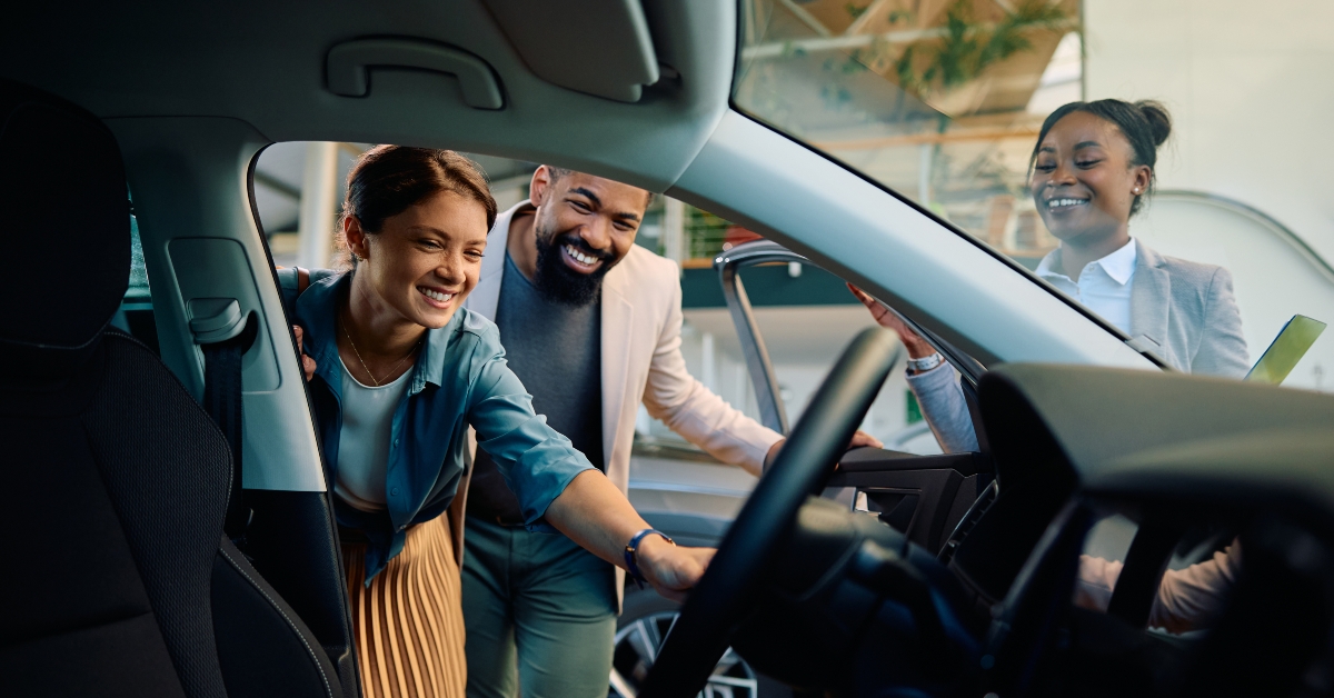 multiracial couple looking at new car