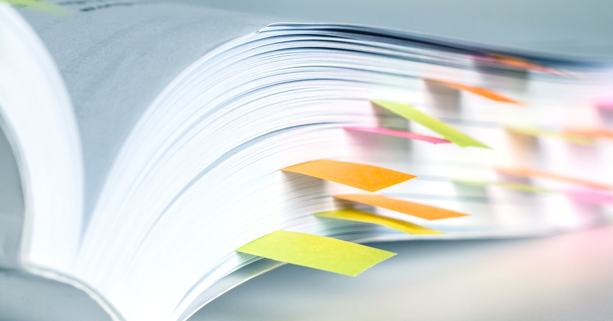 white book marked by sticky note