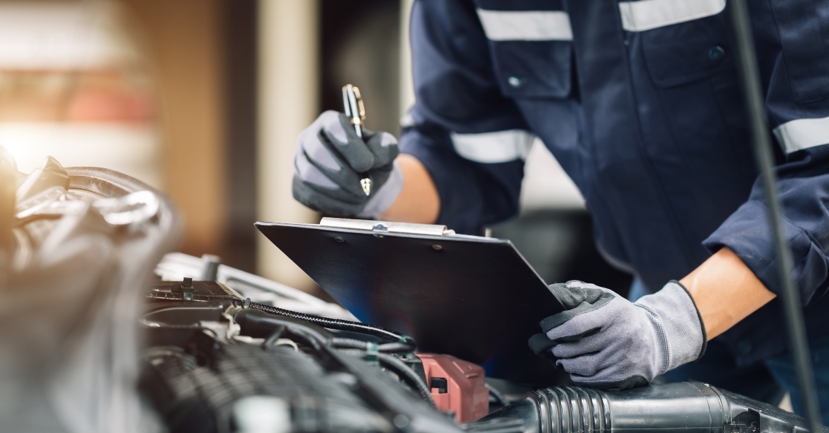 mechanic works on the engine of the car in the garage