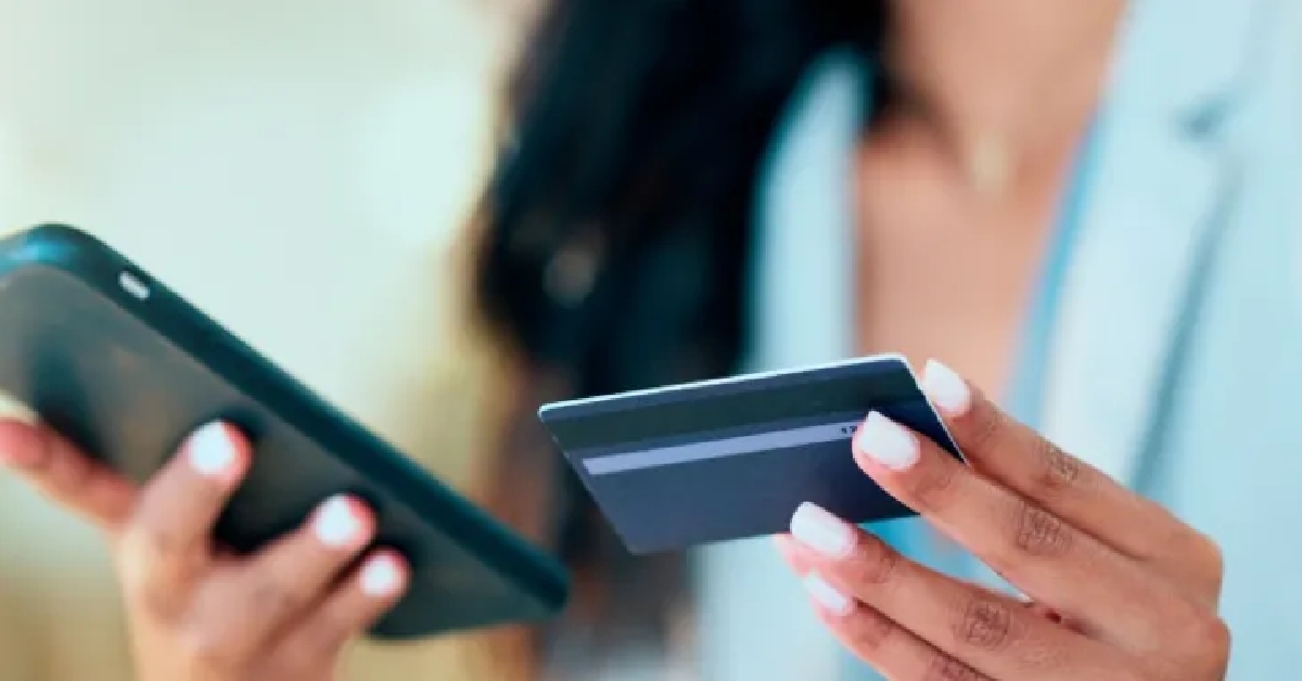 woman holding a credit card and phone