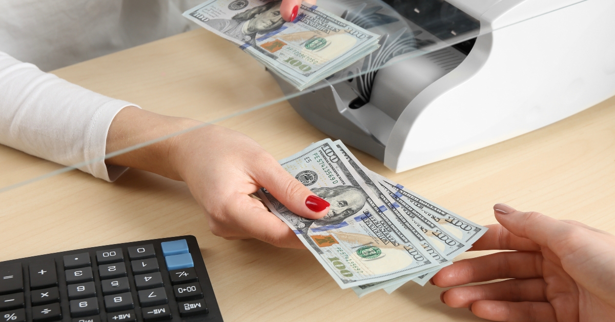 cashier giving dollar banknotes in money exchange