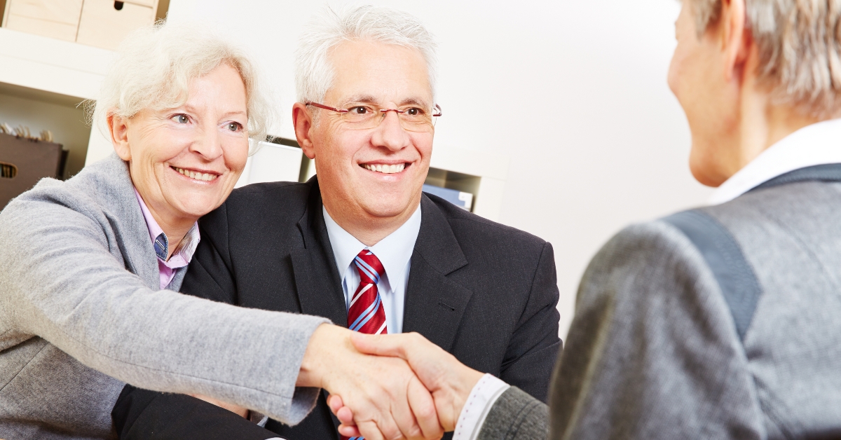 elderly couple shaking hands 