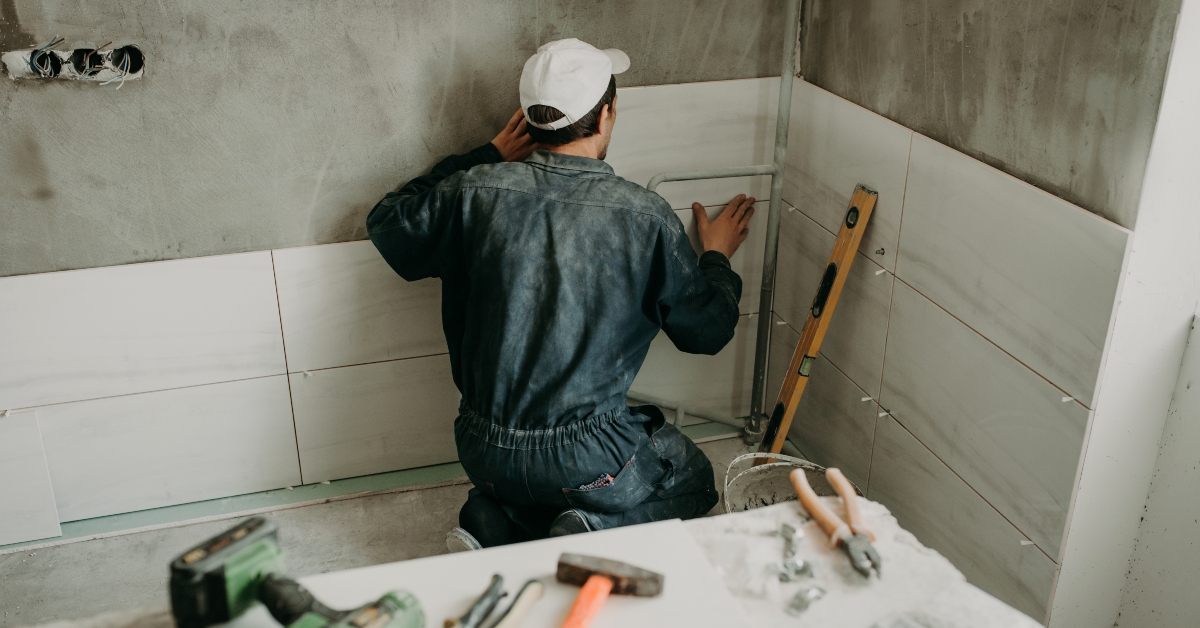 repairman puts large ceramic tiles