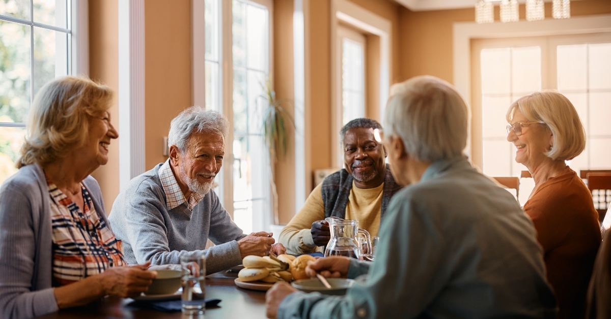 happy seniors talk while eating lunch