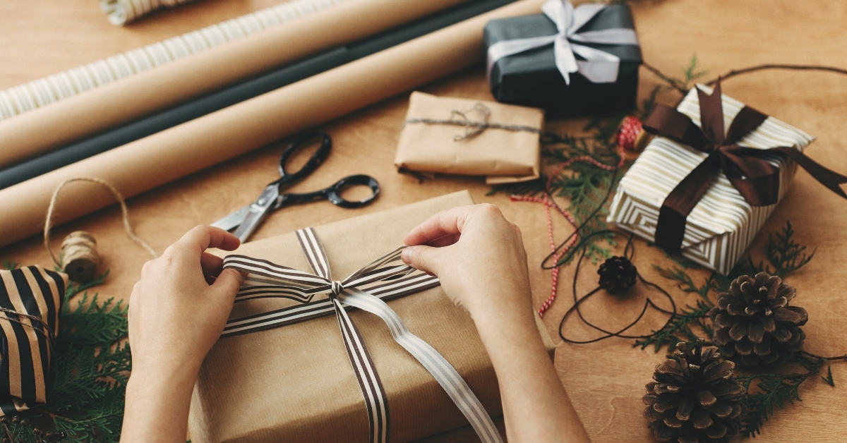 hands wrapping stylish christmas gift box
