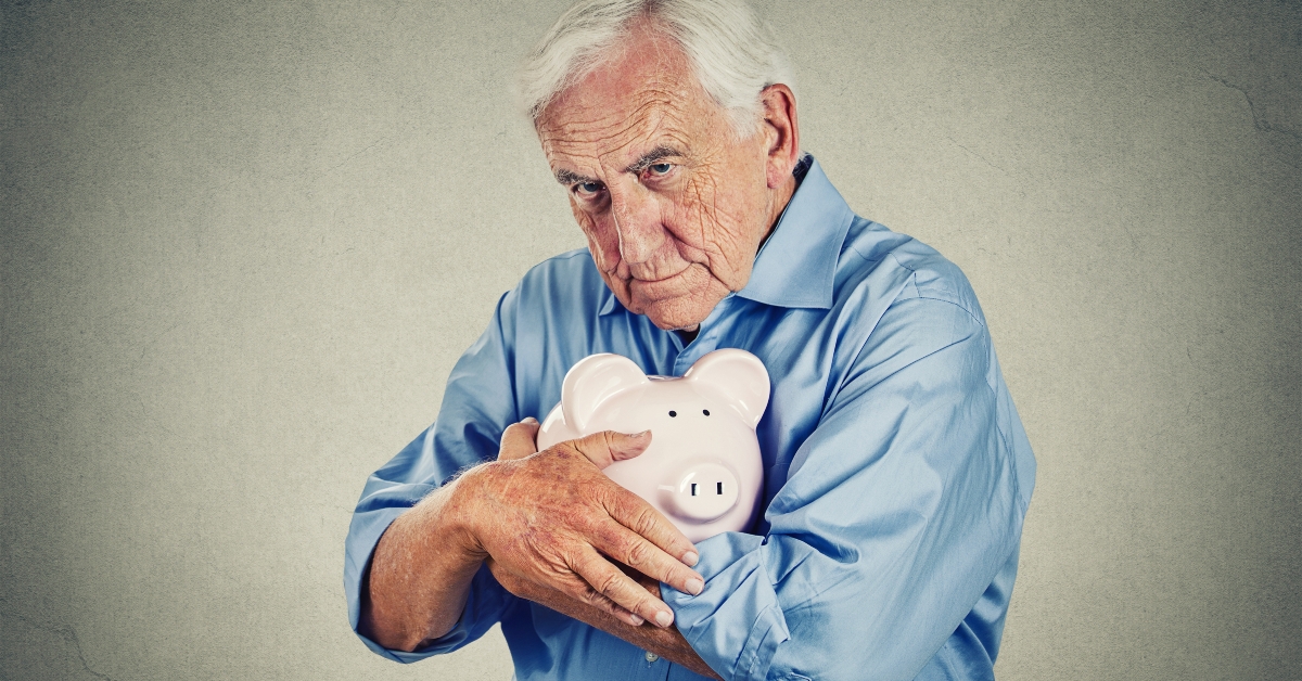 Senior man holding piggy bank