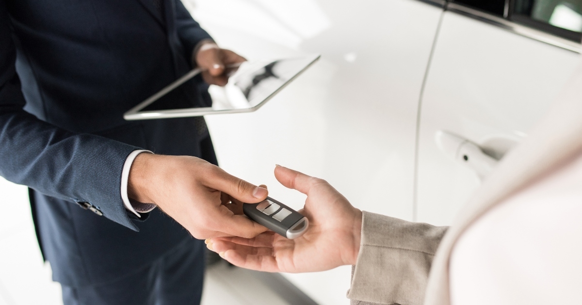 car salesman giving keys to client