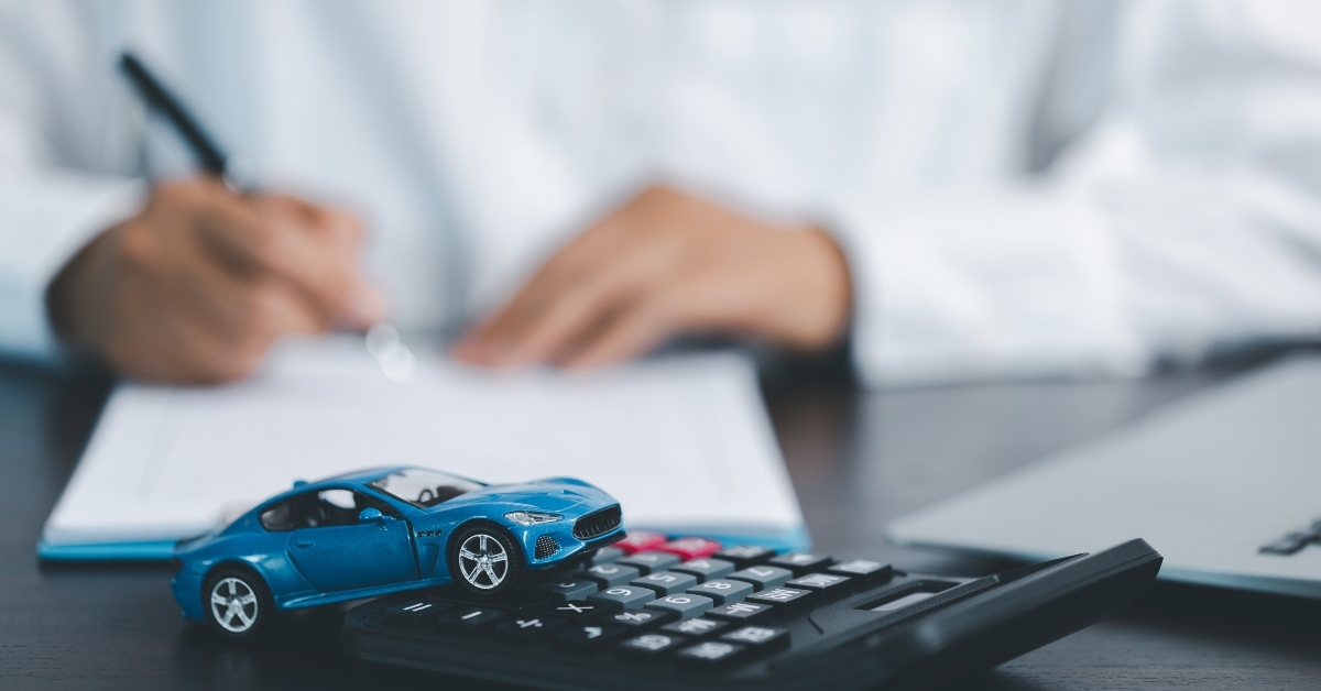 toy car in front of businessman calculating loan