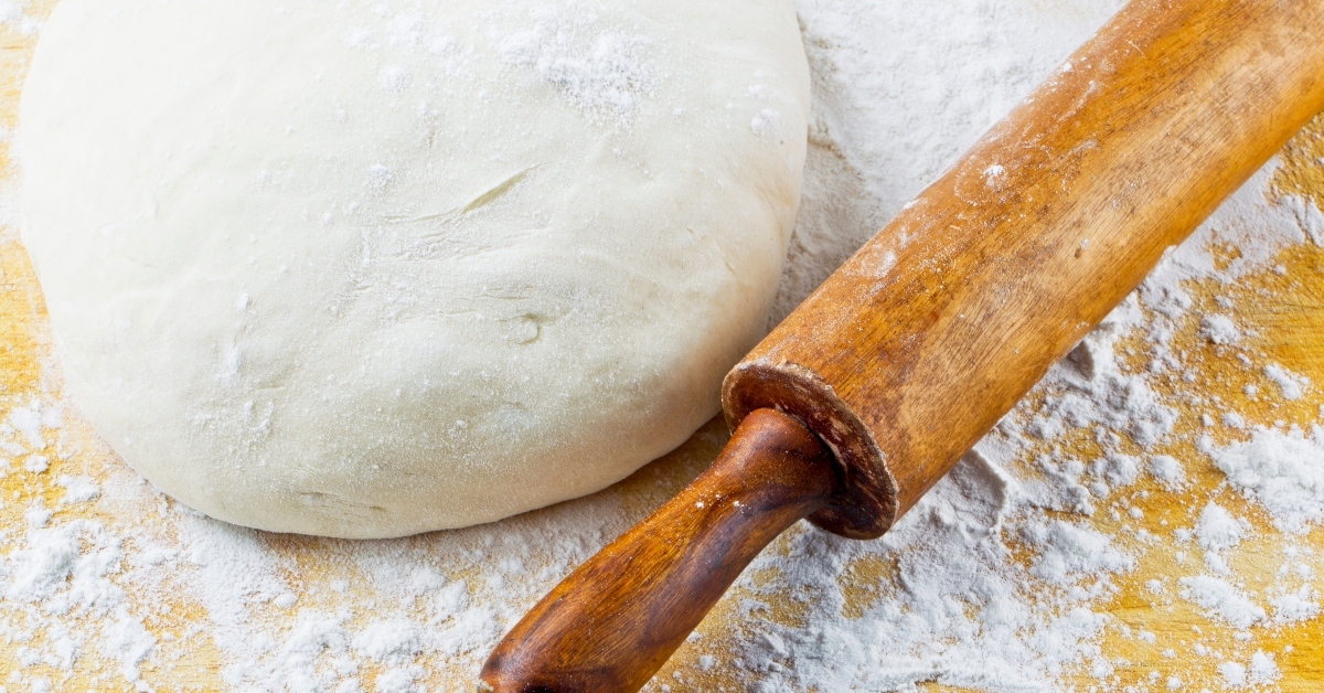 rolling pin with pizza dough 