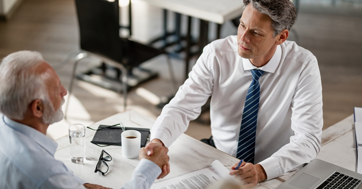 agent and senior man shaking hands
