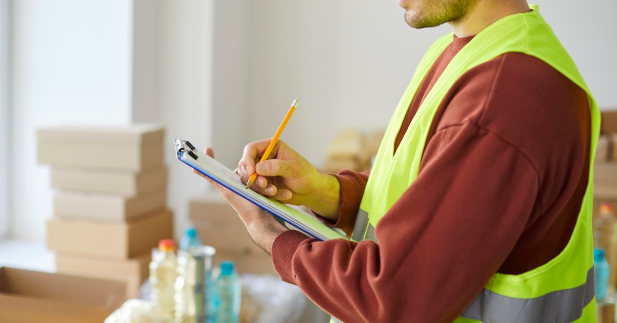 volunteer writing and inspecting warehouse for maintenance
