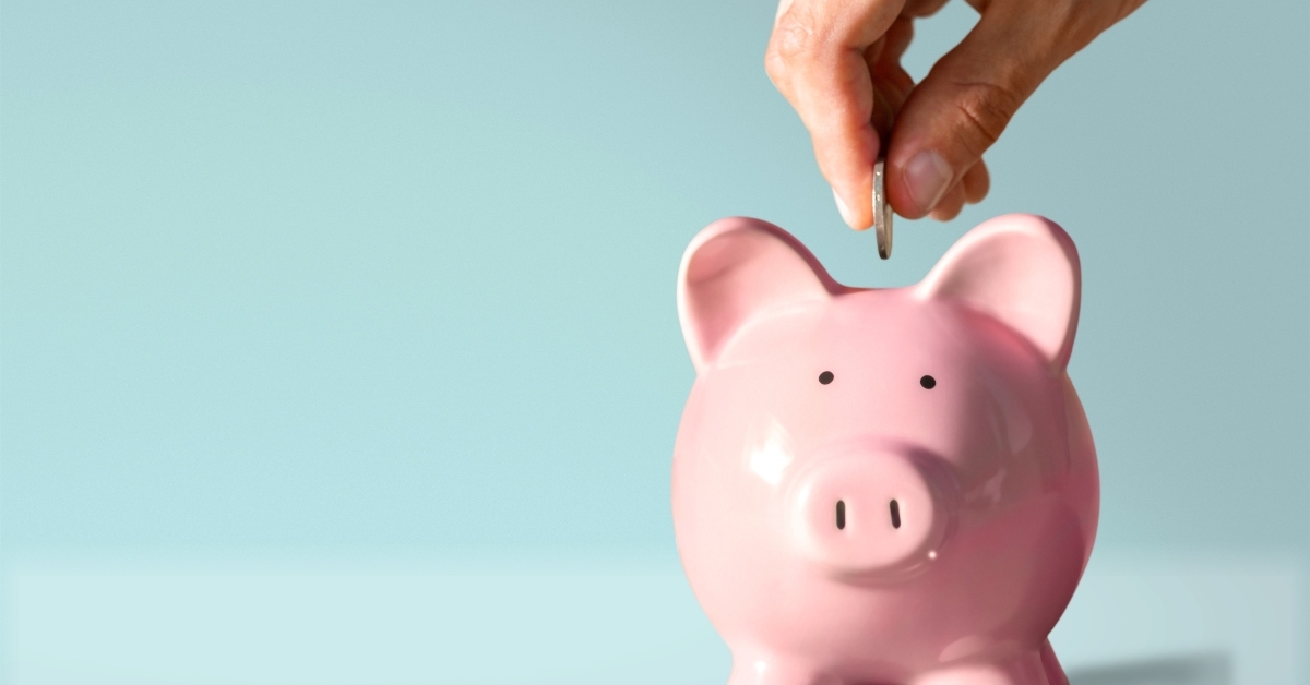 hand putting coin to piggy bank