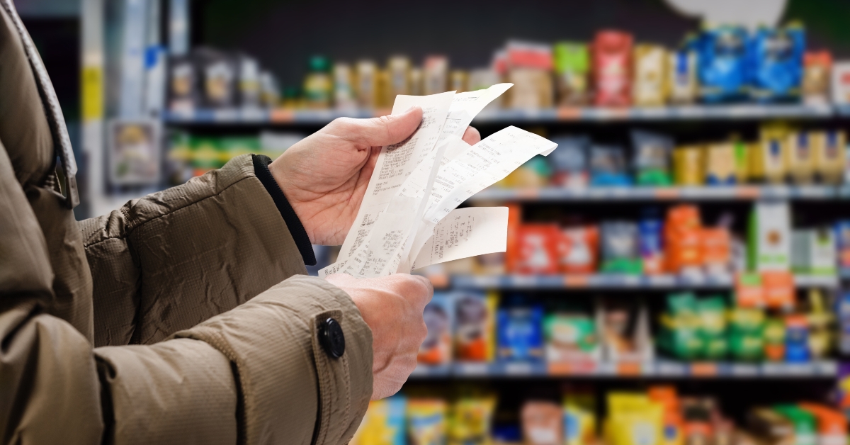 man viewing receipts in supermarket