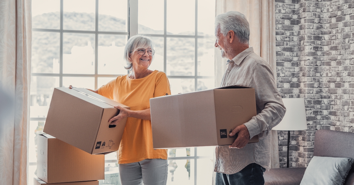 Mature couple carrying cardboard boxes