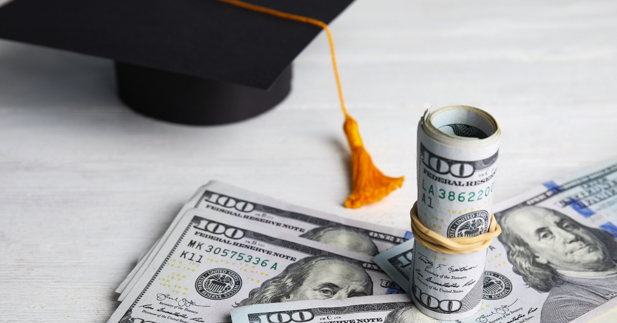 dollar banknotes and a graduation hat