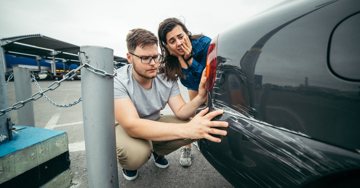 couple looking on car scratch