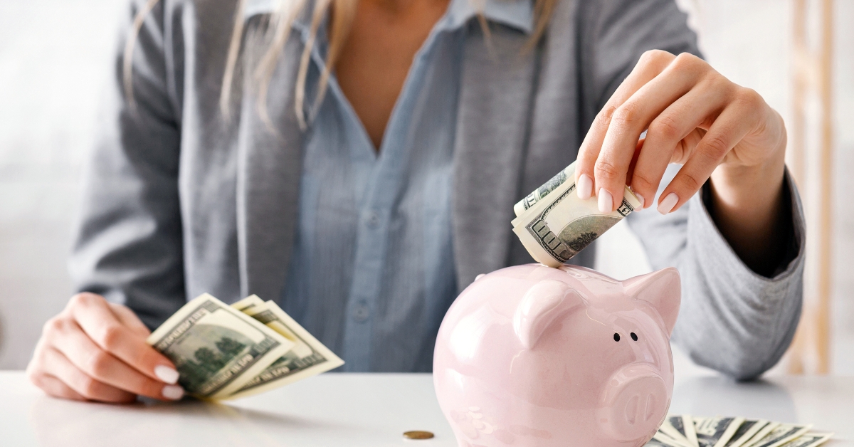 Girl puts money in piggy bank