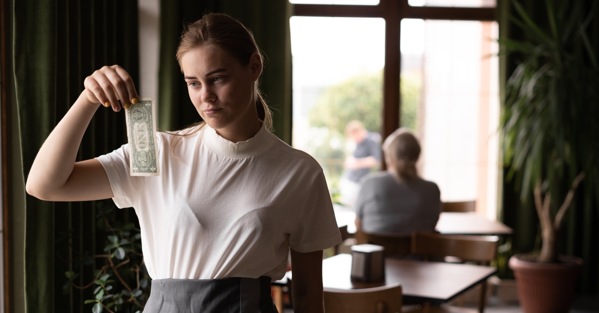 sad waiter in restaurant with tips