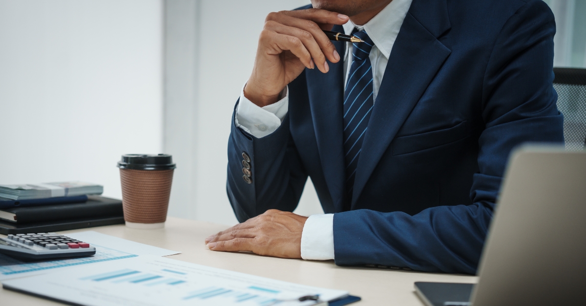 A banker in a suit works at a desk