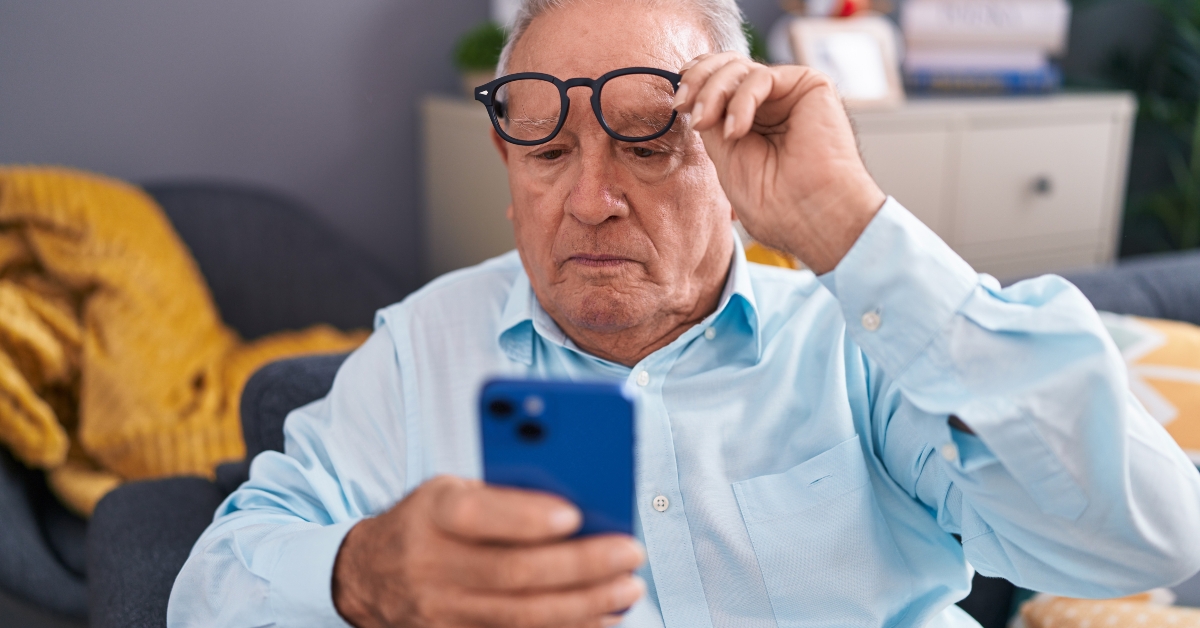 man looking at smartphone screen with vision problem