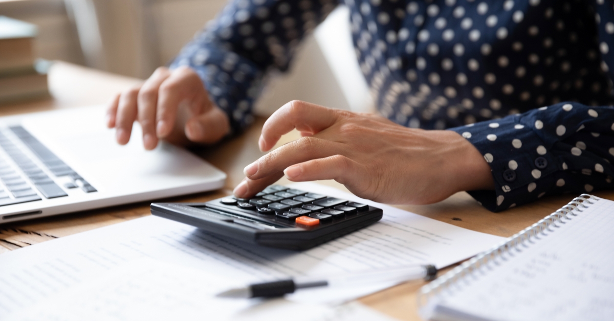 woman using calculator and laptop