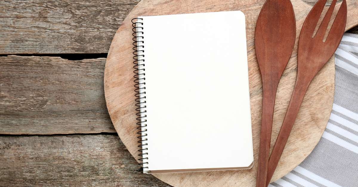blank recipe book and kitchen utensils