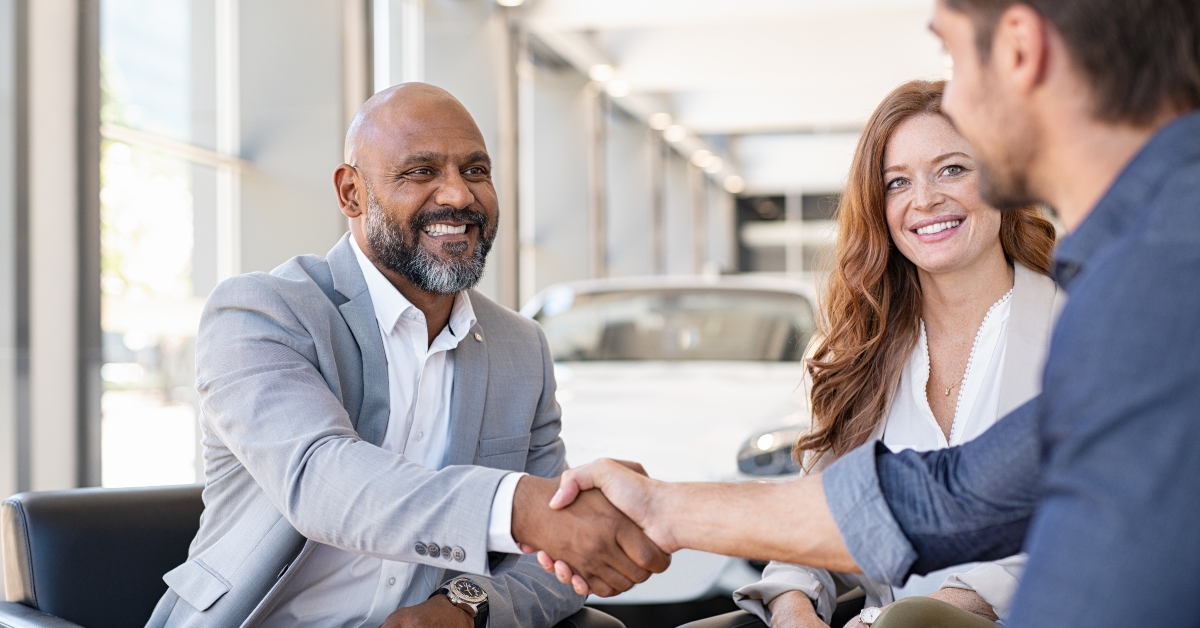 couple buying new car at car dealership