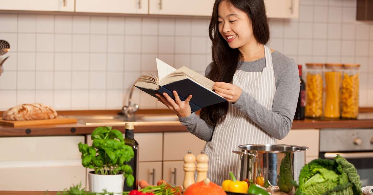 smiling woman looking at cookbook