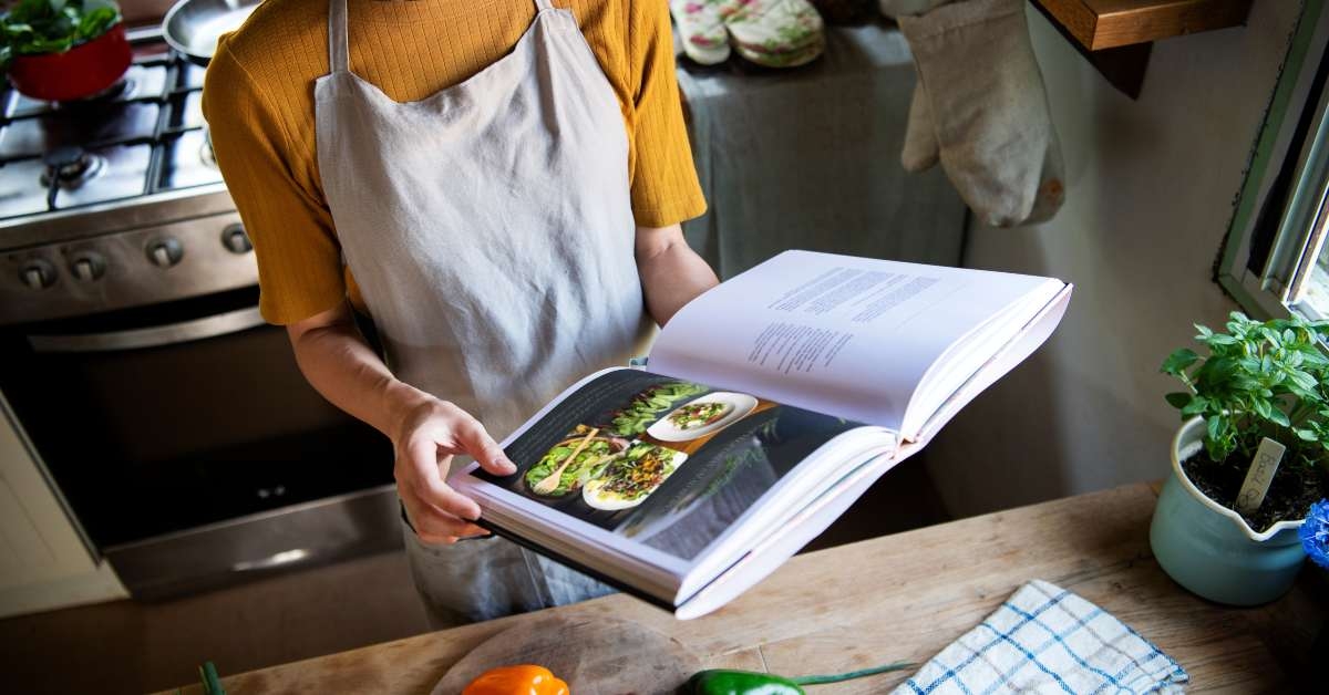 woman reading a cookbook in the kitchen