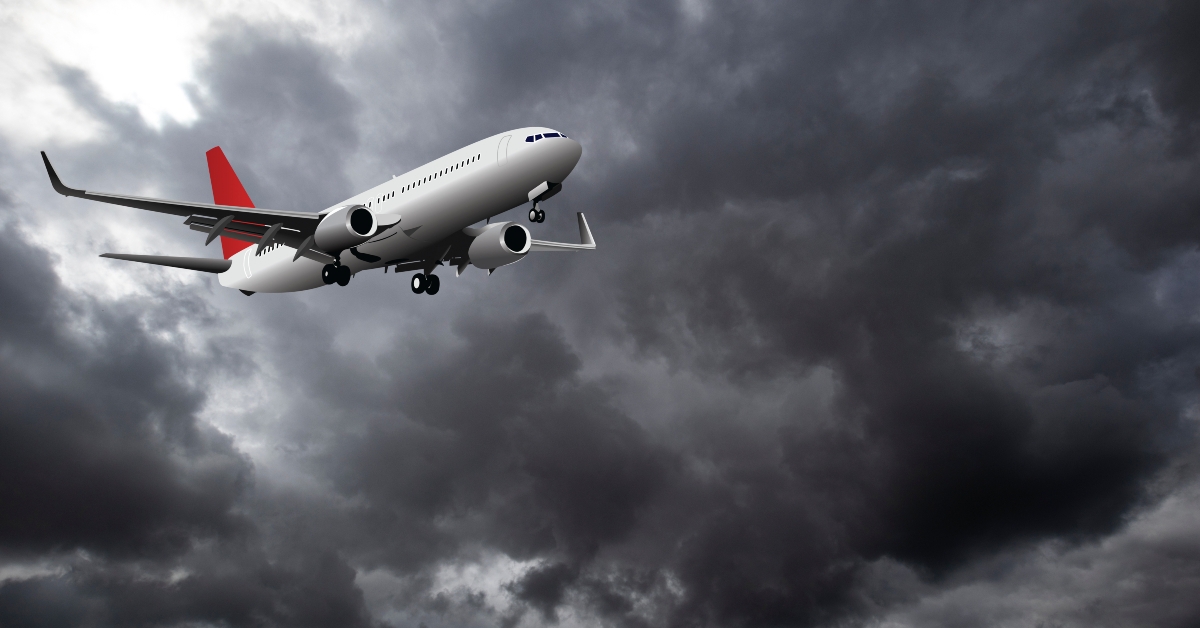 passenger plane flying through dramatic storm clouds