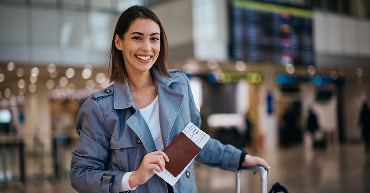 Happy traveler holding her passport at flight ticket