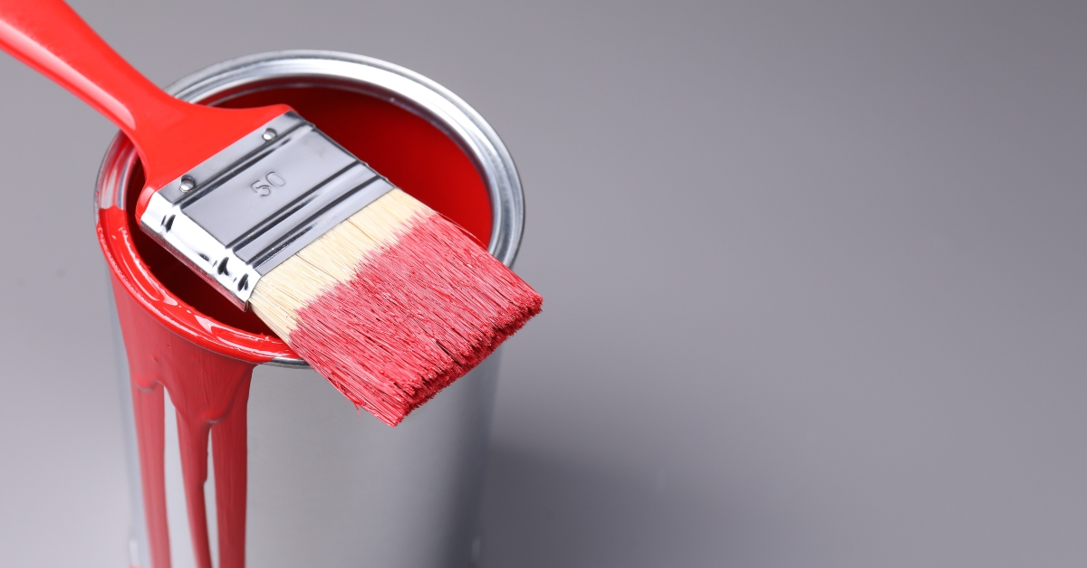 Can of red paint and brush