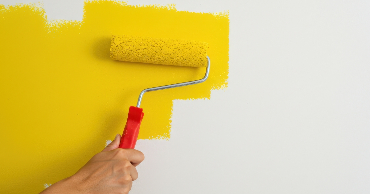 Person painting a white wall