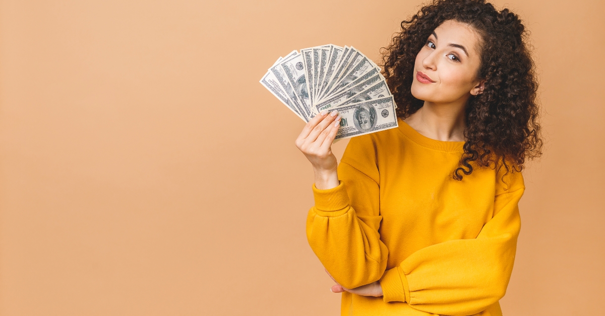cheerful young woman holding money banknotes
