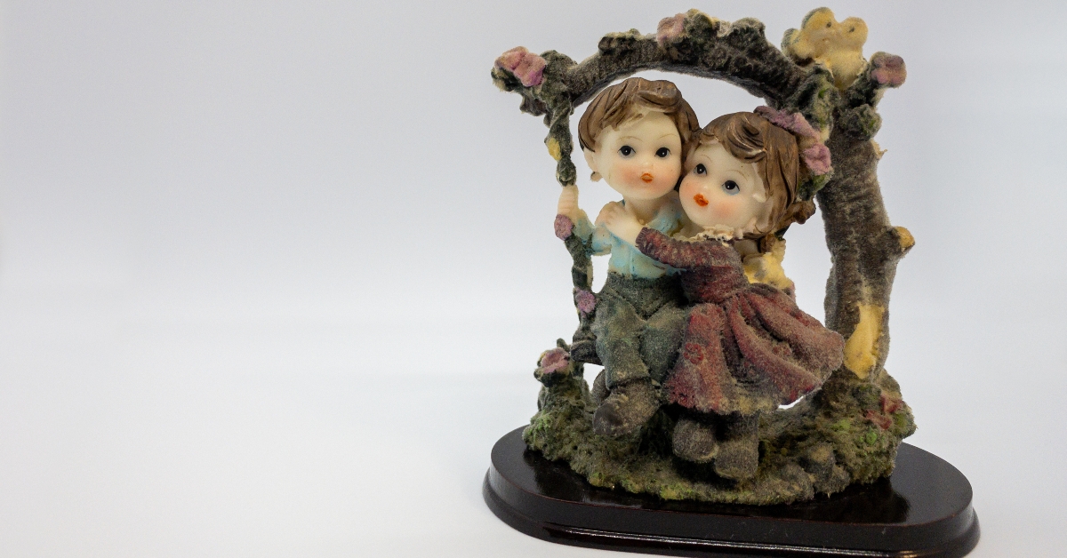 figurine of boy and girl hugging on a swing