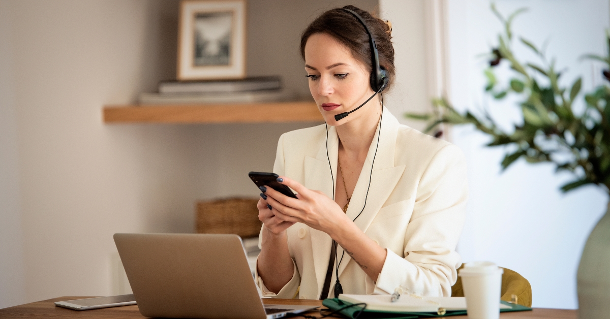 businessswoman wearing headset and using smartphone