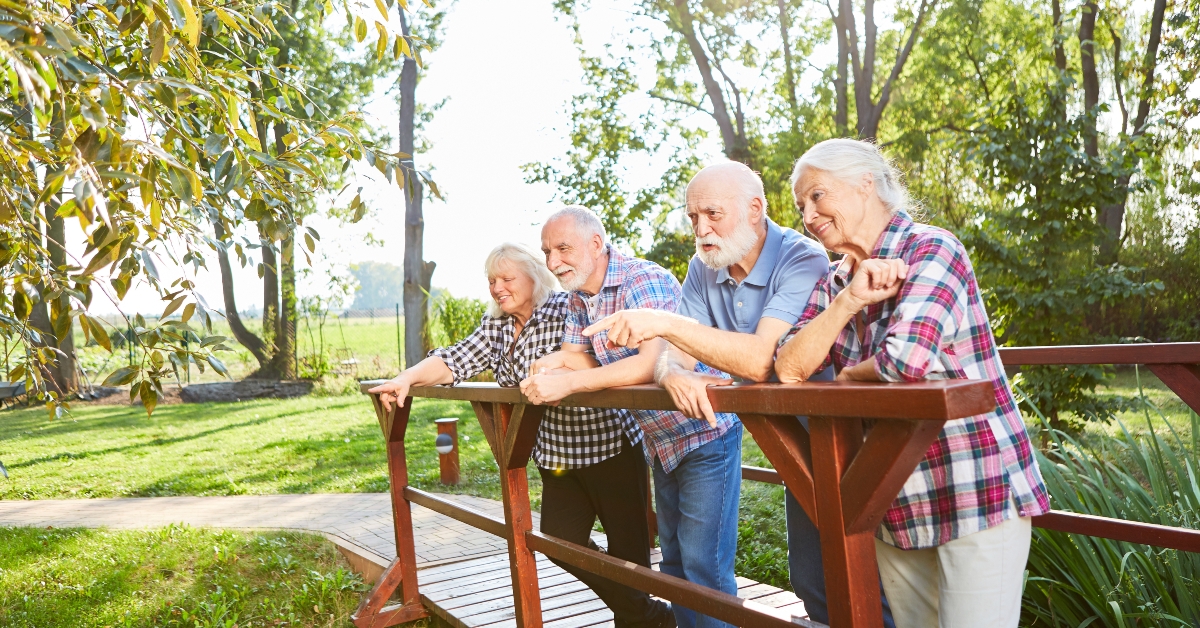 senior group is standing on a small bridge