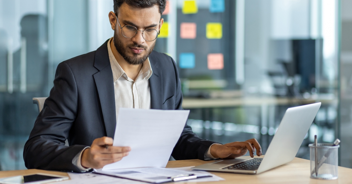 Serious thinking businessman behind paperwork