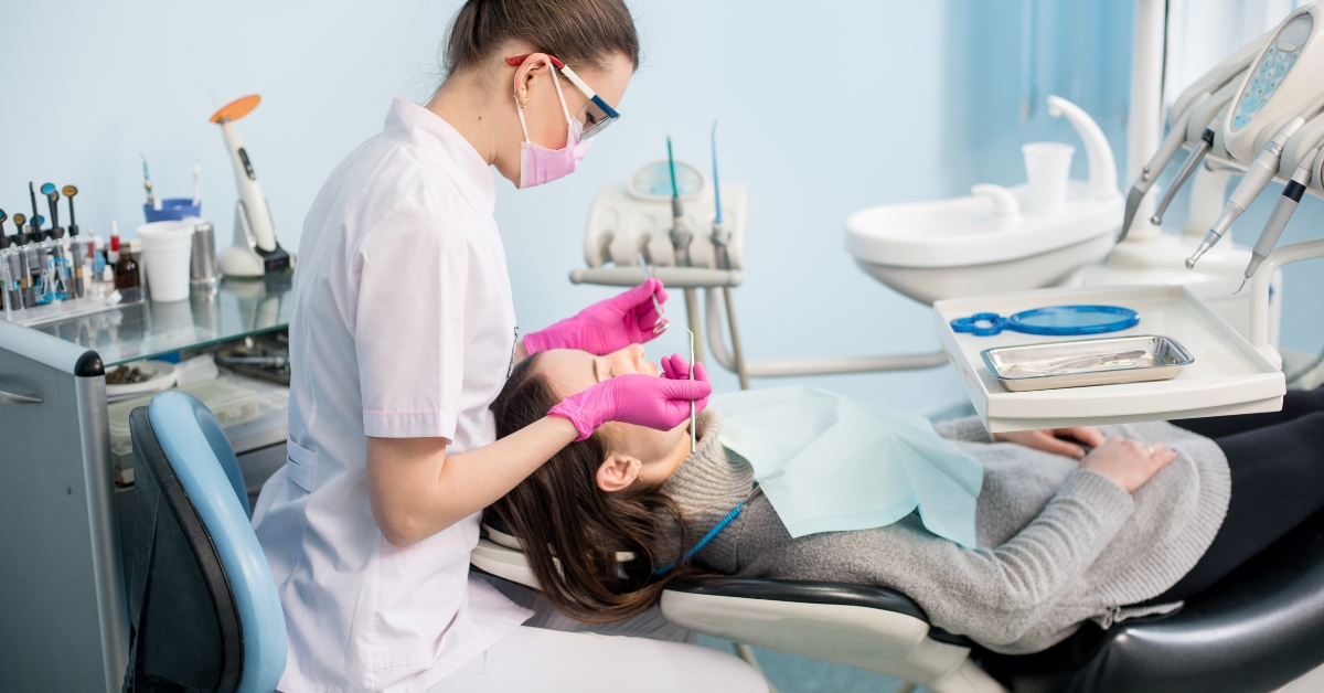 female dentist checking up patient teeth