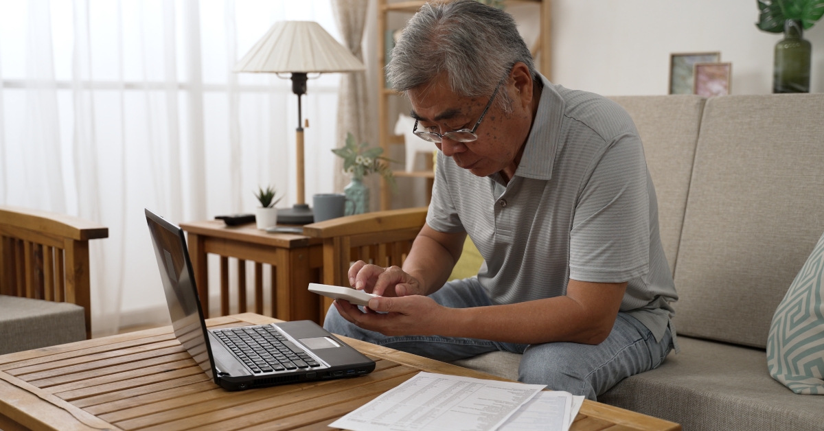 senior man counting on calculator